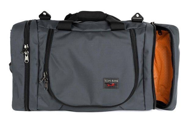A Nebulous Grey (medium grey) Ballistic Aeronaut 45 with the end pocket open showing the Zest (orange) Halcyon.